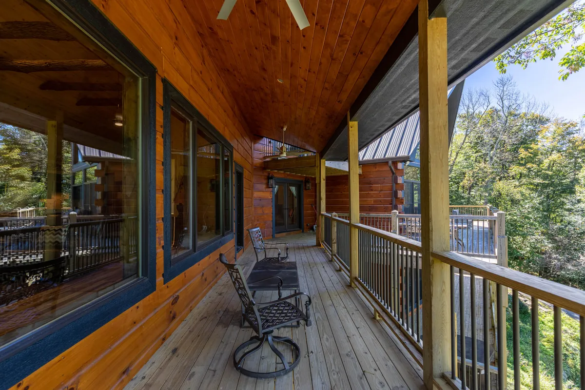 This image features a cozy wooden deck with comfortable rocking chairs, surrounded by dense greenery. The setting feels private and serene, perfect for relaxing with a pet, reading, or simply taking in the sounds of nature.